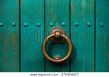 Close Up To An Old Wooden Green Door With A Knocking Ring.