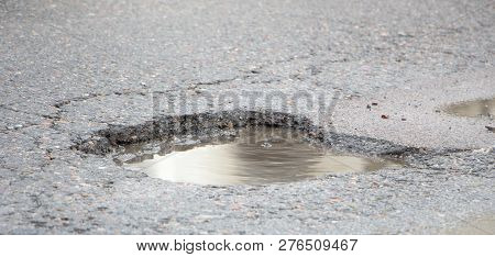There Are Many Potholes On The Roadway Close Up