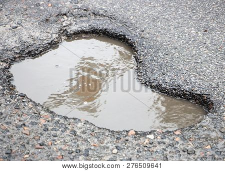 There Are Many Potholes On The Roadway Close Up