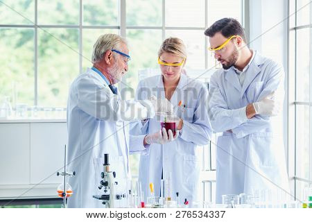 Science Teacher And Students Team Working With Chemicals In Lab