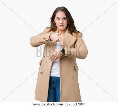 Beautiful plus size young woman wearing winter coat over isolated background In hurry pointing to watch time, impatience, upset and angry for deadline delay