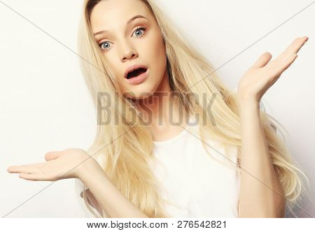 Surprised terrified female gestures with uncertainty, stares at camera, puzzled as doesn`t know anwser on tricky question