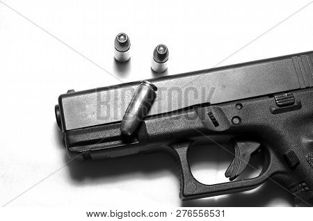 A Black Semi Automatic 9mm Pistol On A White Background With Three Hollow Point Bullets Shown In Bla