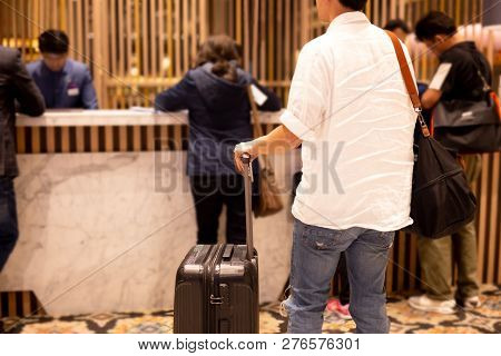Man Holding Passport With Suitcase Waiting To Checking In At Hotel.