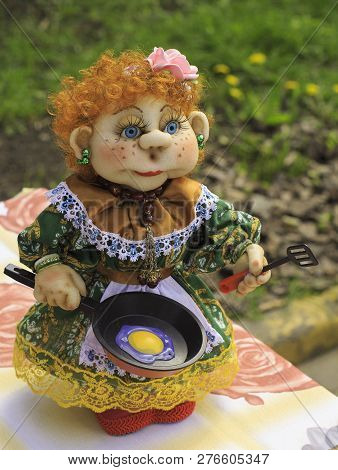 Soft Handmade Doll With A Frying Pan. Handmade Waldorf Soft Toys On Wooden Table With Garden In The 