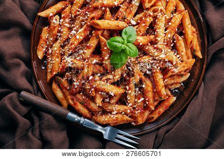 Close-up Of A Portion Of Classic Italian Penne Arrabiata In A Bowl With Basil And Freshly Grated Pec