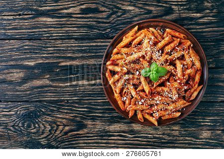 Classic Italian Penne Arrabiata  In A Clay Bowl With Basil And Freshly Grated Peccorino Cheese On A 