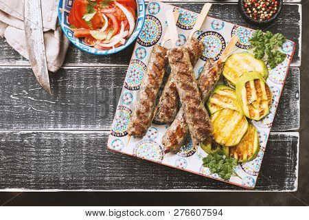Traditional Homemade Grilled Turkish Adana Urfa Kebab, Minced Meat Kebab, On A Plate With Tomato Sal