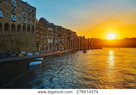 The Sunset Sky Above The Waters Of Vttoriosa Marina With A View On Medieval Senglea Housing And Ramp
