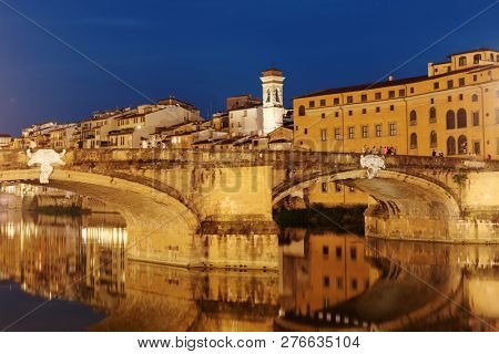 FLORENCE, ITALY - AUGUST 7, 2018: Night view to Ponte Santa Trinita bridge across Arno river. It is the oldest elliptic arch bridge in the world, created in 1569 by Bartolomeo Ammannati