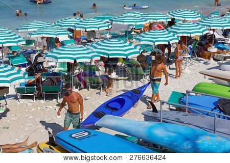 PORTONOVO, ANCONA, ITALY - AUGUST 12, 2018: People on the beach on Adriatic sea in hot season. Portonovo, nestled in the green of Conero Park, is famous for its nature and the beauty of its beaches