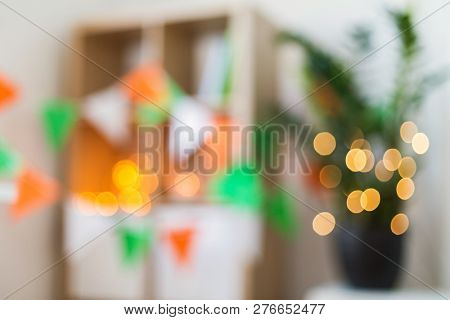 holidays, st patricks day and background concept - blurred bokeh of home interior decorated for party
