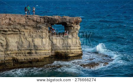 Protaras, Cyprus - July 30 2018: People Standing And Sitting On The Rocks, Enjoying The Crystal Clea