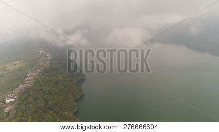 Lake Buyan Shores Covered With Tropical Vegetation On Cloudy Day. Mountain With Slopes Covered Tropi