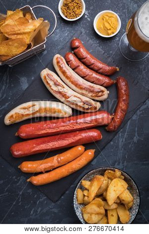 Grilled german sausages with mustard and fried potato chips