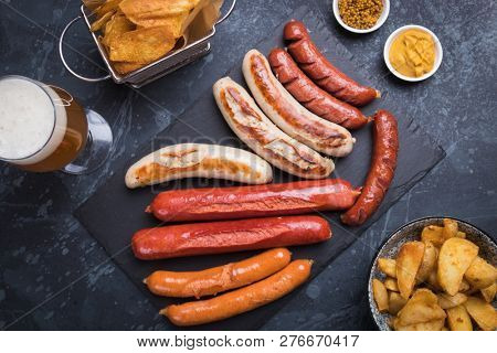 Grilled german sausages with mustard and fried potato chips