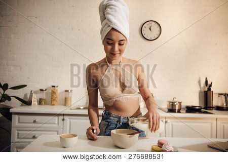 Smiling Asian Girl In Lace Bralette And Towel On Head Pouring Milk Into Bowl With Corn Flakes