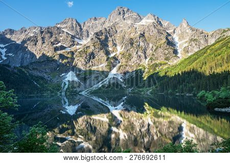 Landscape of High Tatras in the spring. Snowy mountain tops and beautiful sky. Mountain Rysy, Morskie Oko.