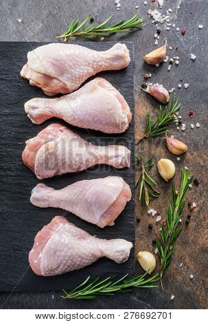 Chicken legs with spices and salt  ready for cooking on cutting board.