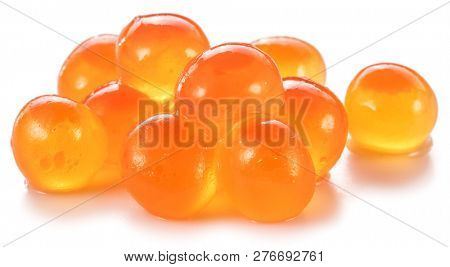 Several salmon caviar on white background. Macro picture.