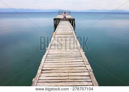 Woman Sits On The Pier, Messonghi, Corfu, Greece