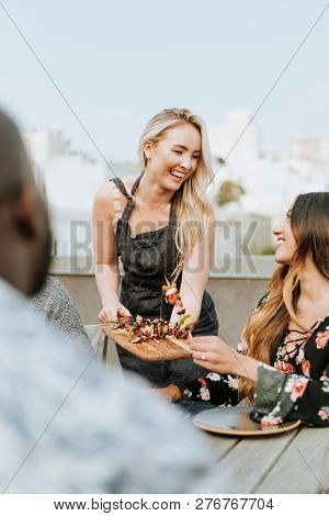 Woman serving her friends vegan barbeque skewers