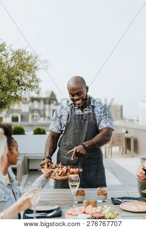 Cheerful chef serving grilled vegan barbeque skewers