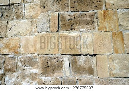 Old Antique Wall From Demaged Sandy Brown Stones Front View Closeup