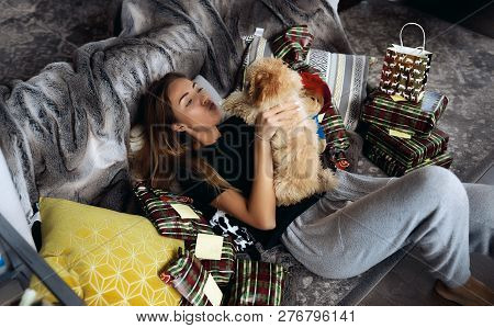 Kissing Lady Pet Her Cutie Puppy With Red Curlies. Lying On Sofa Among Presents From Friends And Fam