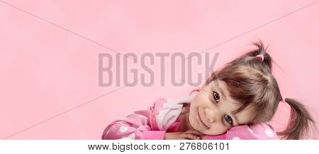Portrait Of A Cute Little Girl With Pigtails On Pink Background. Little Girl In Pink Jacket With Whi