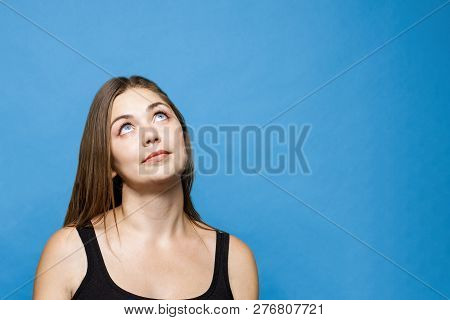 Young Causacian Woman With Blue Eyes Up Thinging Or Dreaming About Something. Wigh Dark Hair, Isolat