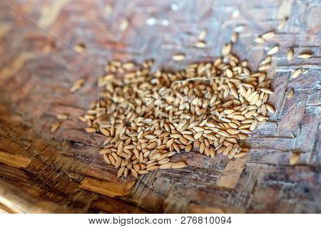 A Pile Of Unpeeled Rice In Woven Bowl