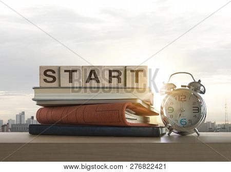 Wooden Blocks With The Word Start, Notebook, Books And Clock On Table With Panoramic City Skyline Ba
