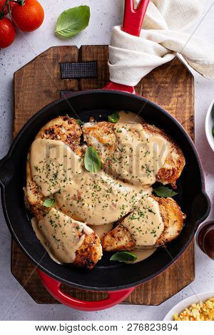 Cooked Chicken Breast Seared In A Cast Iron Skillet With Creamy Pan Sauce