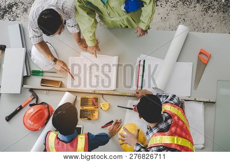 Top View Of Group Of Engineer, Technician And Architect Planning About Building Plan With Blueprint 