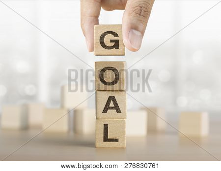 Hand Arranging Wooden Blocks With The Word Goal. Goal, Success, Growth, Mindset Concept.
