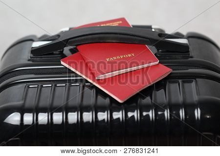 A Travel Bag And Two International Passports On It Under The Handle