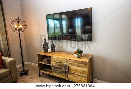 Wall Hung Flat Screen Television Over Wooden Cabinet