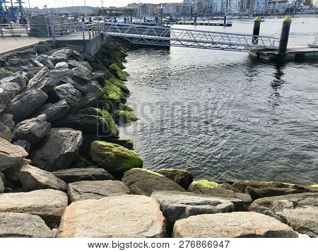 View Of The Harbour From Over Some Rocks On Galicia Spain