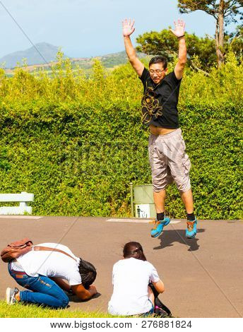 Curepipe / Mauritius Island - 28. October, 2018: Unidentified Chinese tourist jumping and exercising in city park. Asian people traveling around the world.