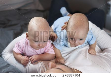 Young Father With His Newborn Twins Lying In Bed. Selective Focus