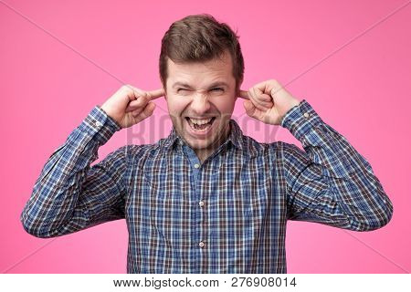 Handsome Young Man Portrait With Fingers In Ear Not Listening Expression