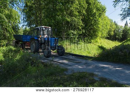 Solovki, Republic Of Karelia, Russia - June 25, 2018:tractor With Trailer Moving Along A Forest Road