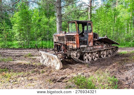 Old Skidder At The Forest In Summertime. Skidding Machine For Timber Industry