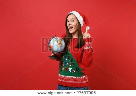 Excited Young Santa Girl Pointing Index Finger Up With Great New Idea, Holding World Globe Isolated 