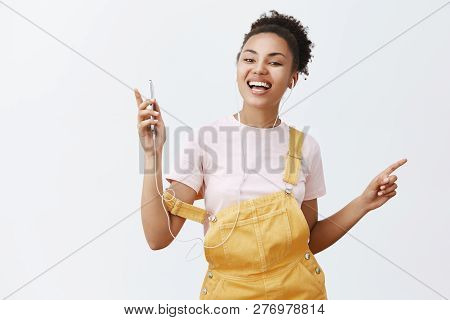 Mini Concert In My Ears With Brant New Earphones. Portrait Of Charming Carefree African Woman In Sty