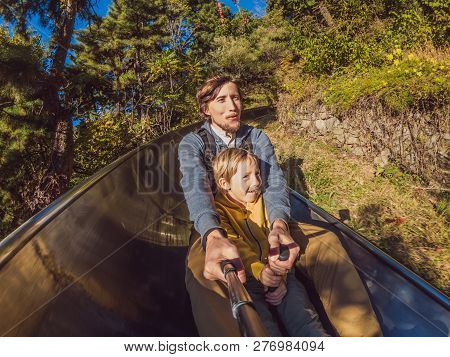 Dad And Son Have Fun On Alpine Roller Coaster