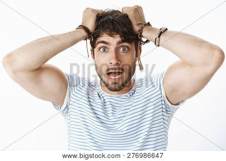 Worried And Panicking Young Confused Guy With Blue Eyes Pulling Hair Out Of Head And Open Mouth Feel