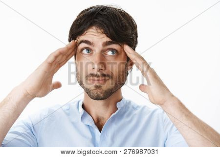 Portrait Of Thoughtful And Creative Young Male Designer With Beautiful Eyes And Beard Trying Focus A