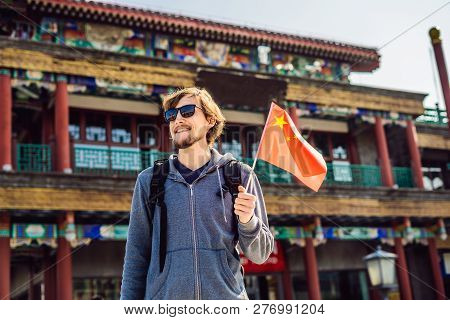 Enjoying Vacation In China. Young Man With National Chinese Flag On The Background Of The Old Chines